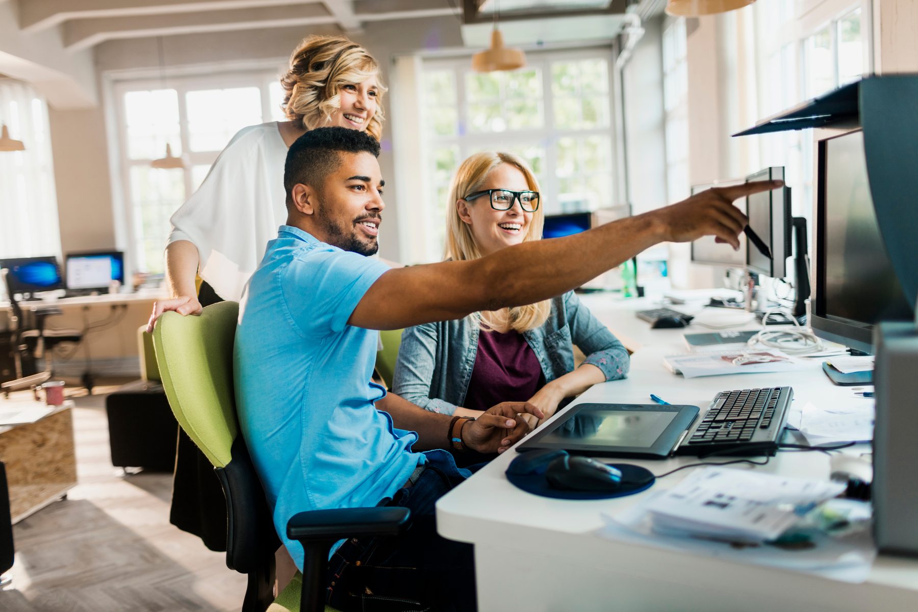 Creative software team collaborating at a computer